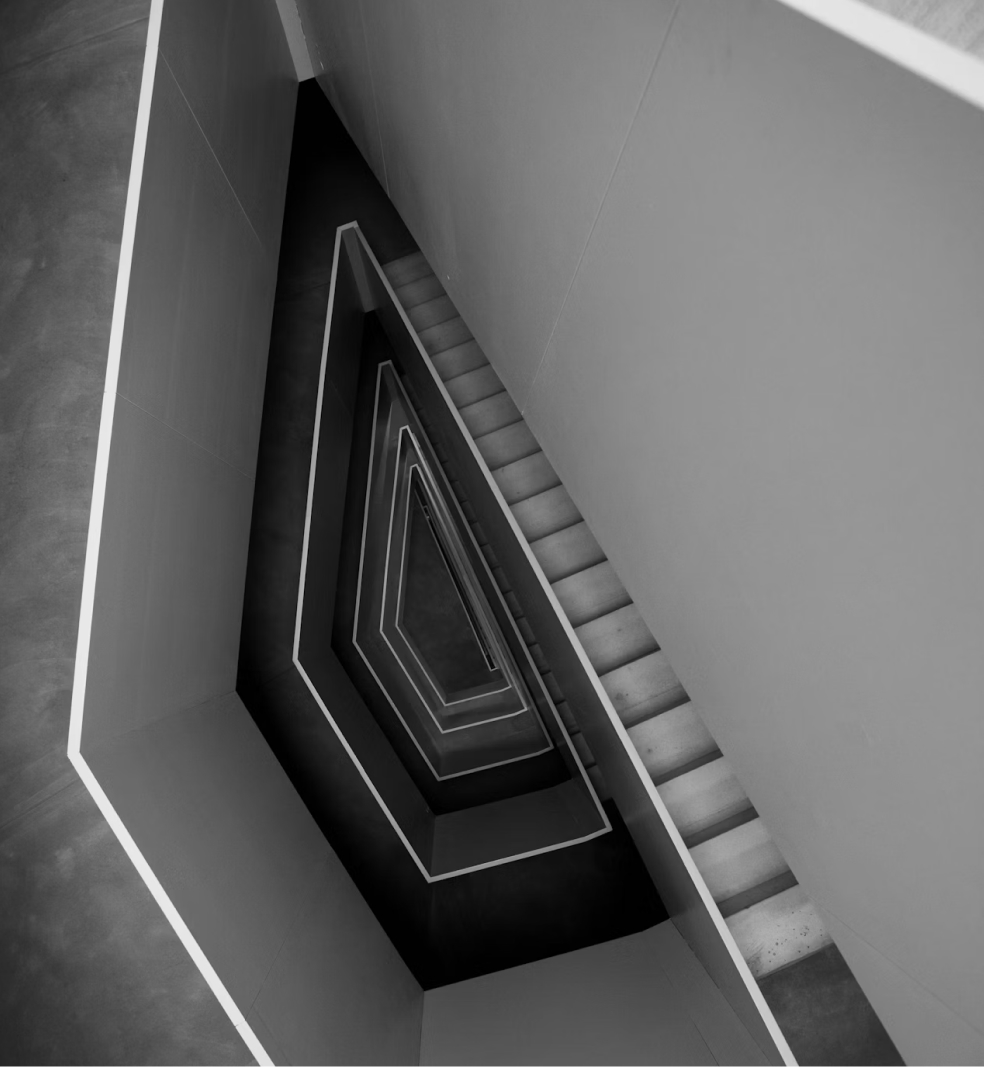Minimalistisches Treppenhaus in Schwarz-Weiß mit geometrischer Spiralarchitektur von oben fotografiert